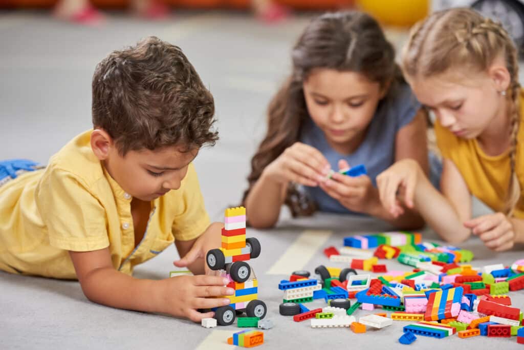 Children playing together in the classroom in kindergarten. Active learning concept