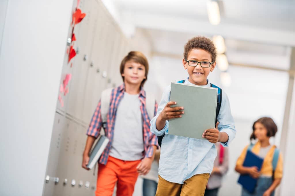 Student achievement concept cute elementary kids with books at school