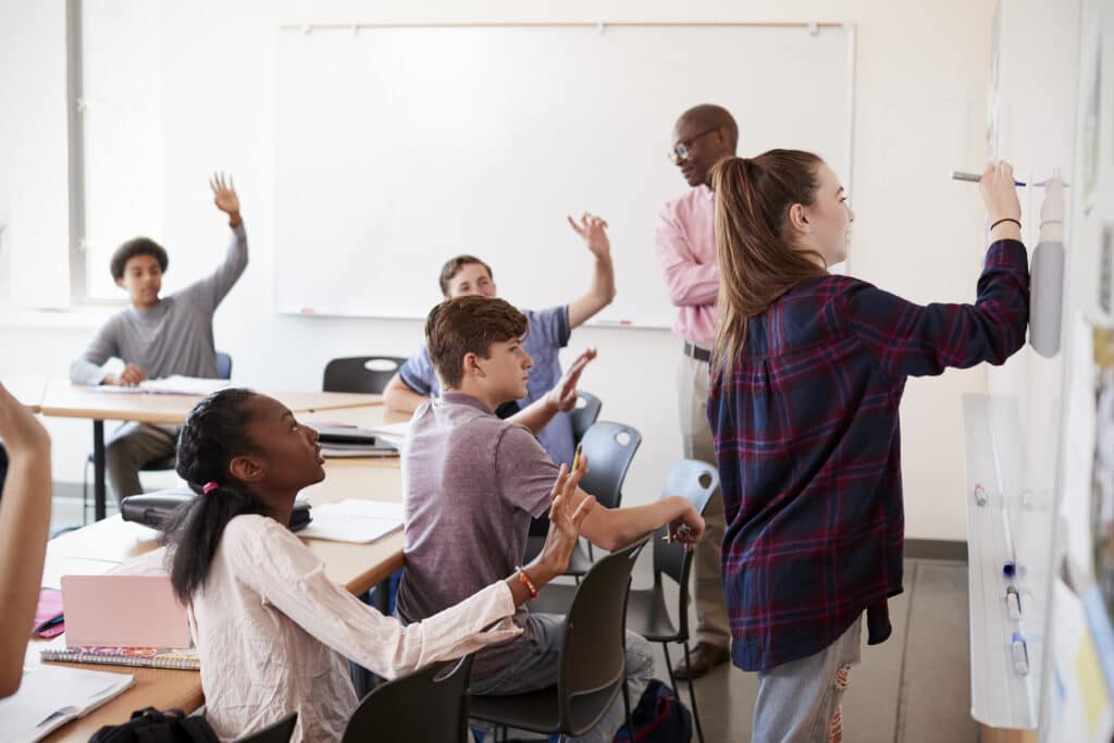 enhancing student engagement concept female-teacher-writing-on-whiteboard