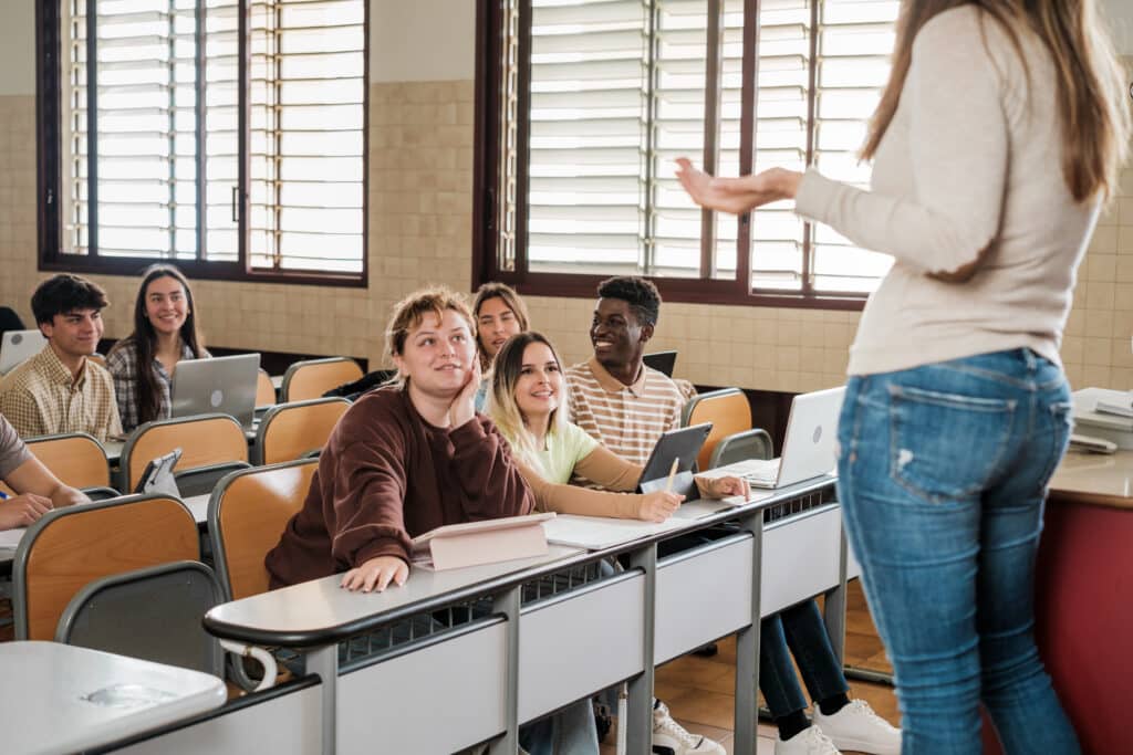 High school students listening to a teacher at the head of the class