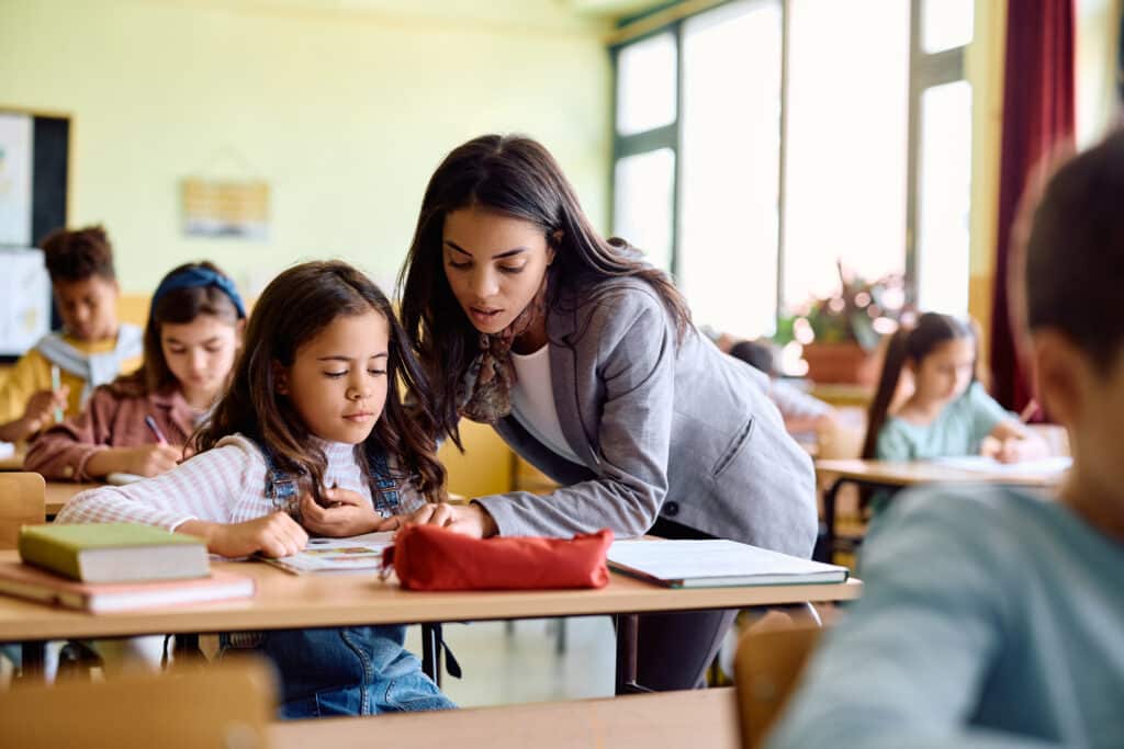 student centered learning concept with hispanic female teacher assisting schoolgirl during a class in the classroom.