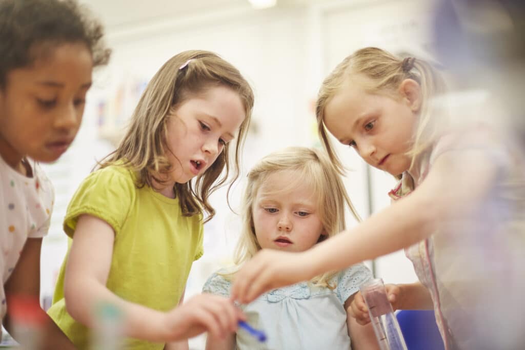 Primary schoolgirls doing experiment in classroom