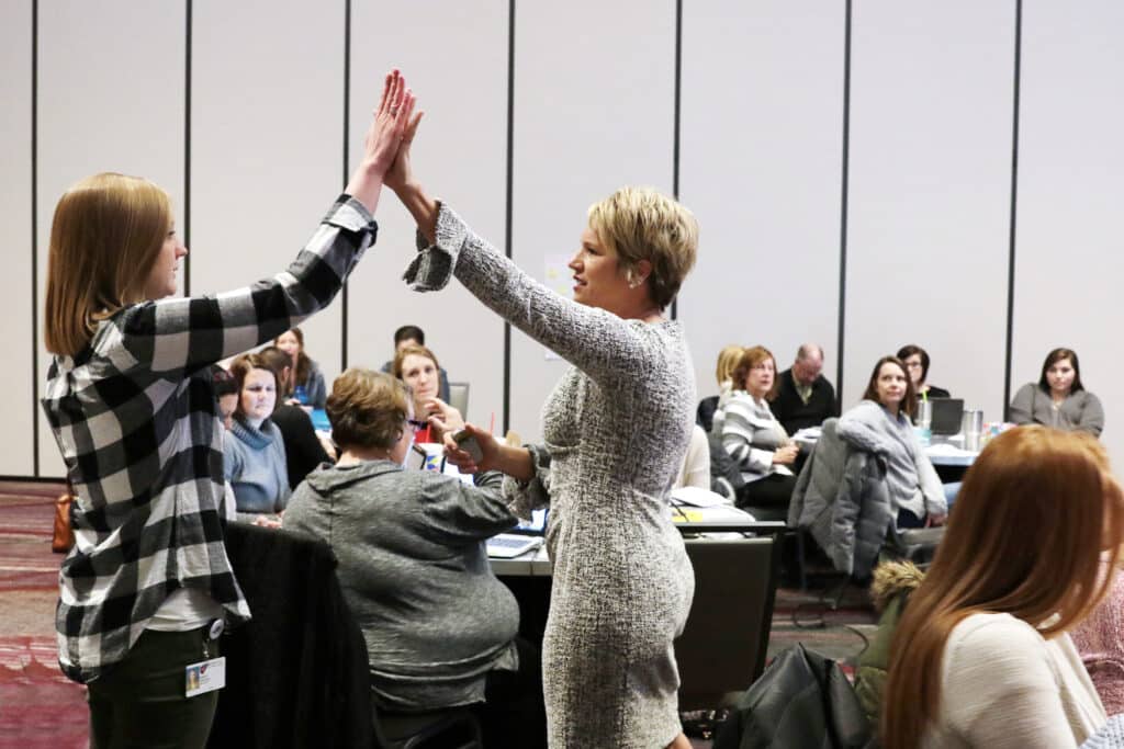 Strobel Education Kim high five at Workshop
