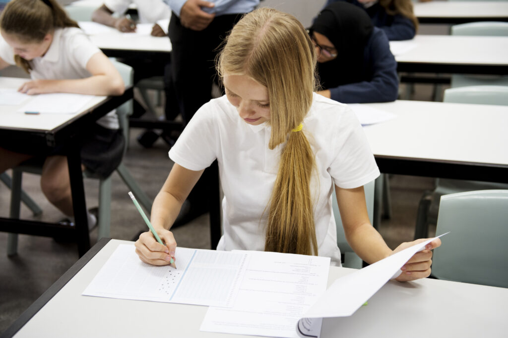 Students doing the exam in classroom competency-based education concept