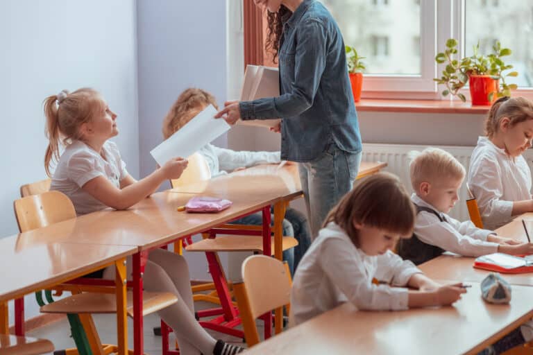 standards based education concept - Teacher gives the student a tested and graded test