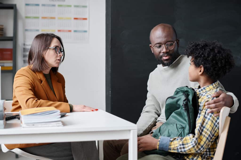 Young teacher talking to father of boy family engagement concept