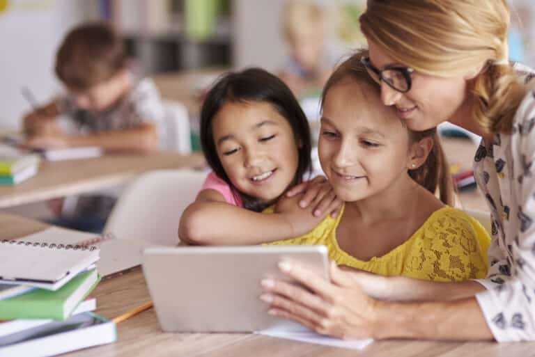 Student-centered learning concept -Teacher helping pupils with digital tablet
