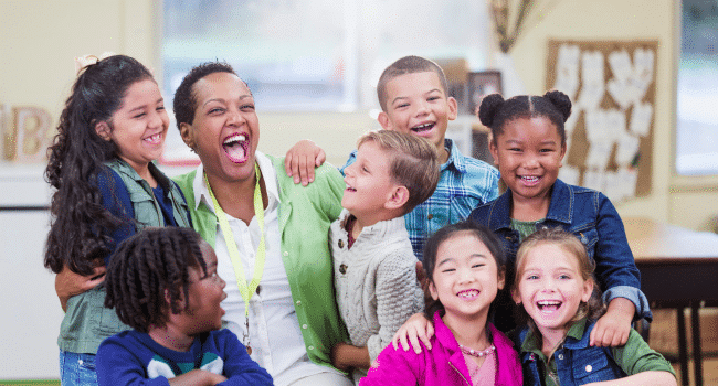 Teacher happily sitting with students